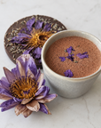 Cup of Blue Lotus, with lavender and ceremonial cacao on a marble surface