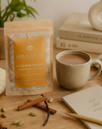 Herbal Cacao Golden Focus package with a cup of cacao on a wooden table.
