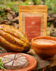 Ceremonial cacao Signature Blend by Herbal Cacao with cacao pod and traditional drink in a natural setting