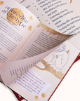 Open journal with decorative text and illustrations on a white background