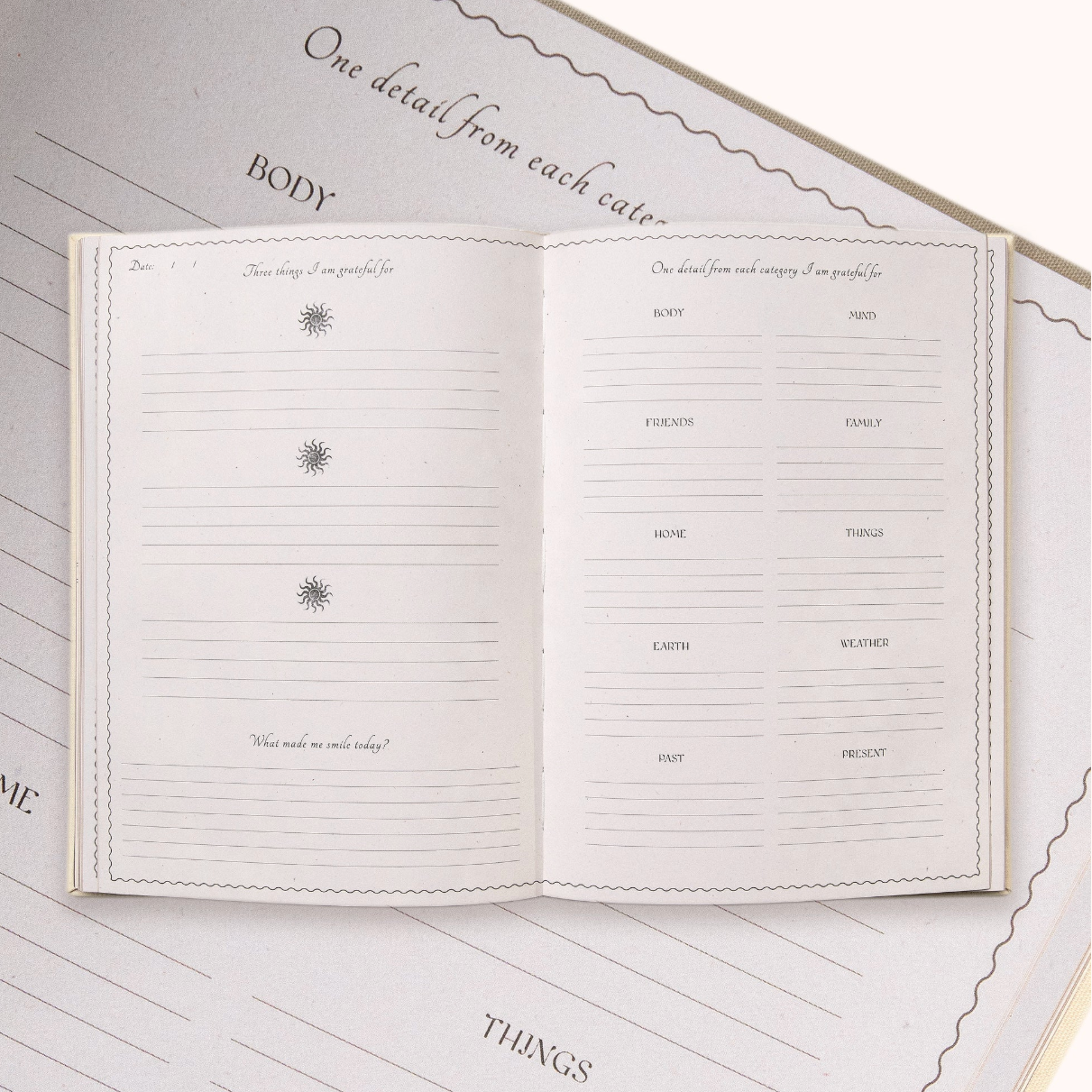 Open Gratitude Journal with lined pages on a matching cover, featuring text and design elements.