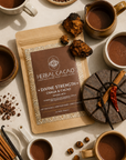 Herbal Cacao packaging surrounded by cacao, chaga, and ingredients on a beige surface.