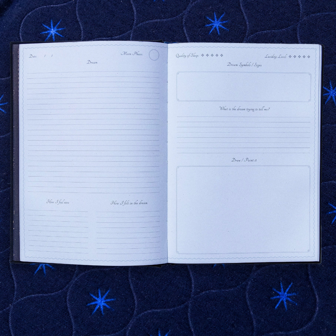 Open dream journal with lined pages on a dark blue fabric background with star patterns