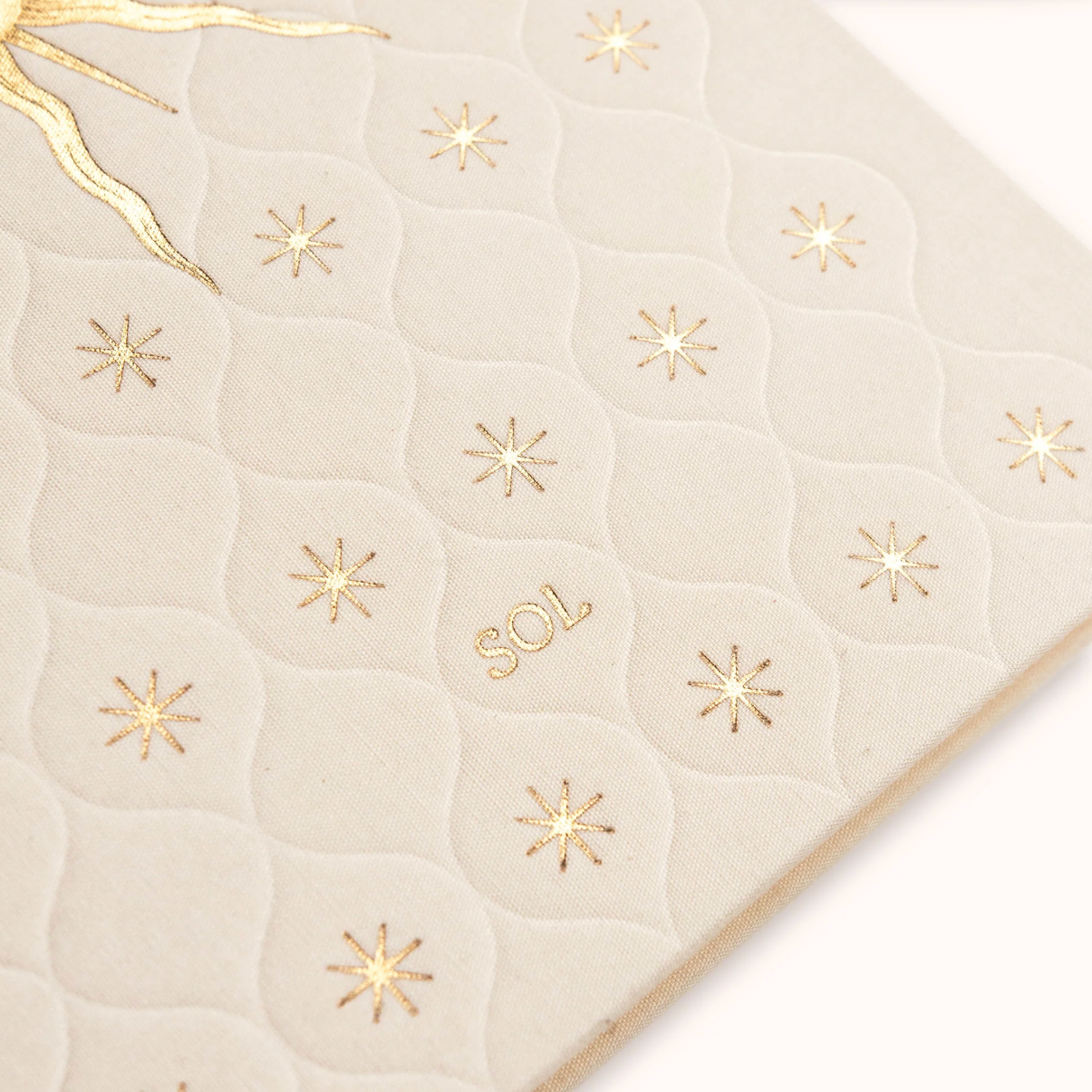 Beige quilted surface with gold star patterns and 'SOL' branding.
