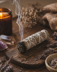 Sage bundle, candle, crystals, and lavender on a wooden surface